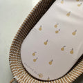 Woven basket with a pink pouch featuring lemon designs on a light background