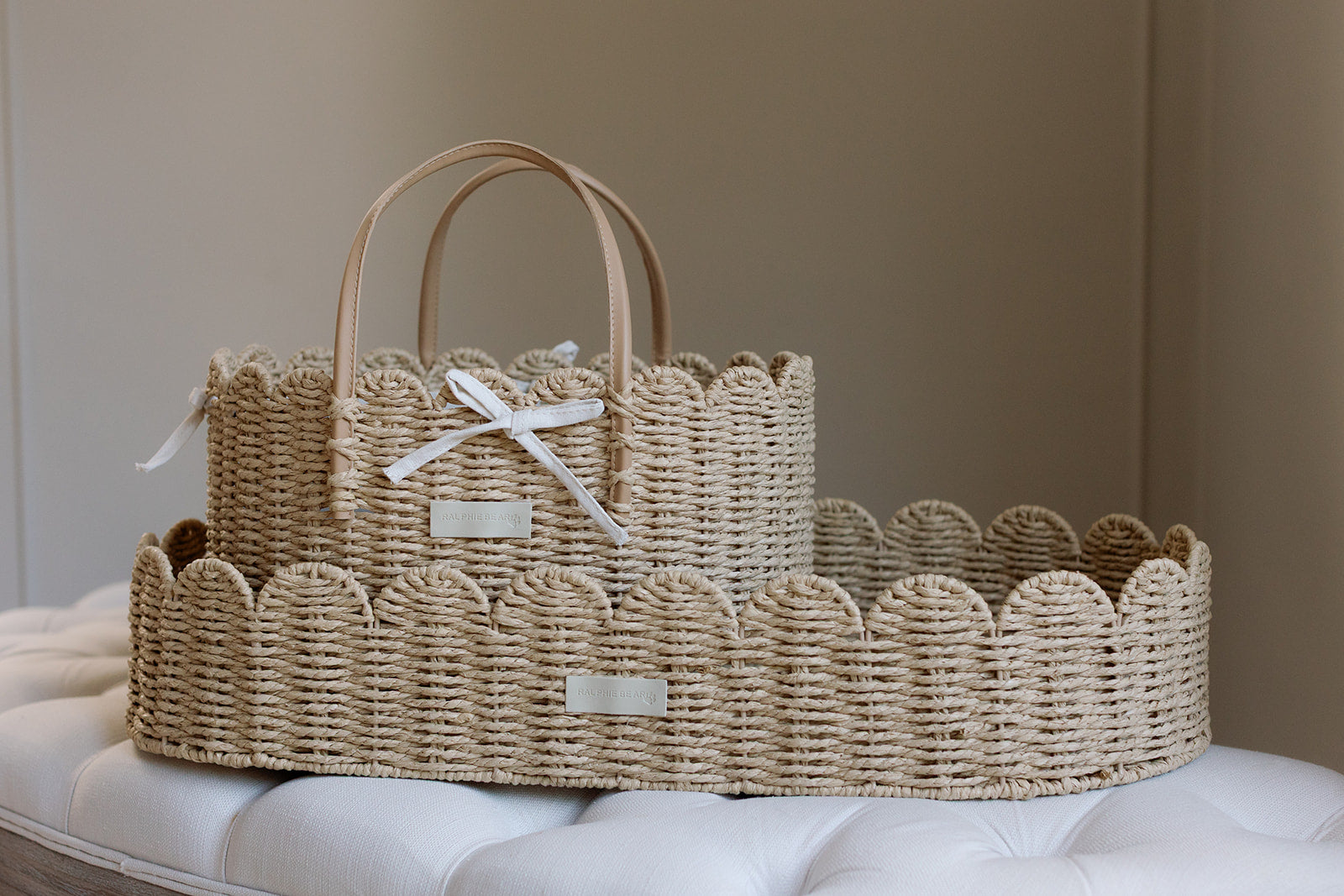 Woven basket with handles on a white surface against a beige wall