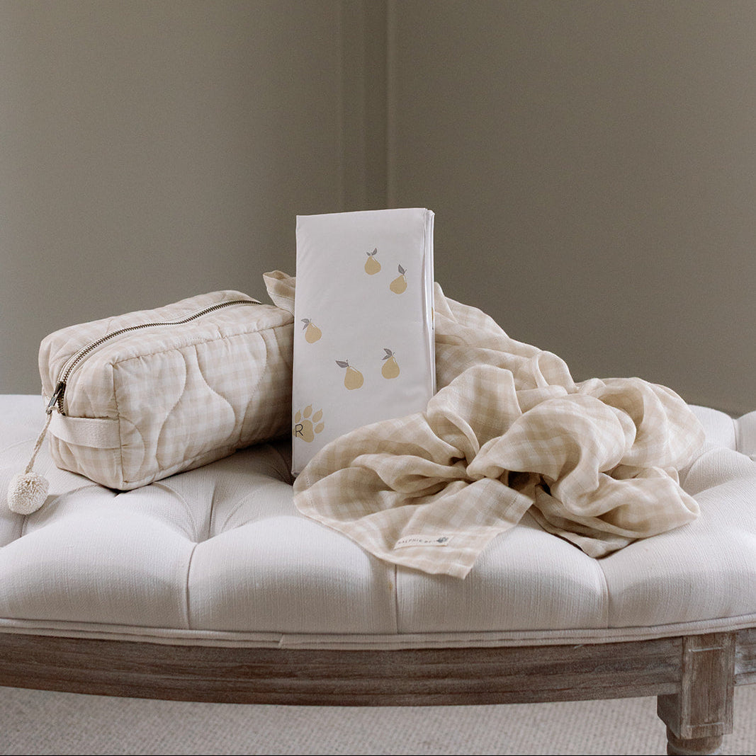 White cushion with a pattern on a beige sofa against a plain wall