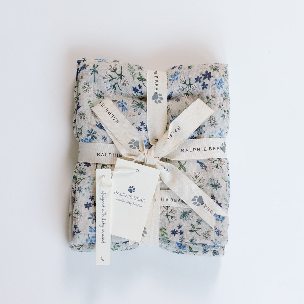 Gift wrapped in floral paper with a bow on a white background