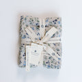 Gift wrapped in floral paper with a bow on a white background
