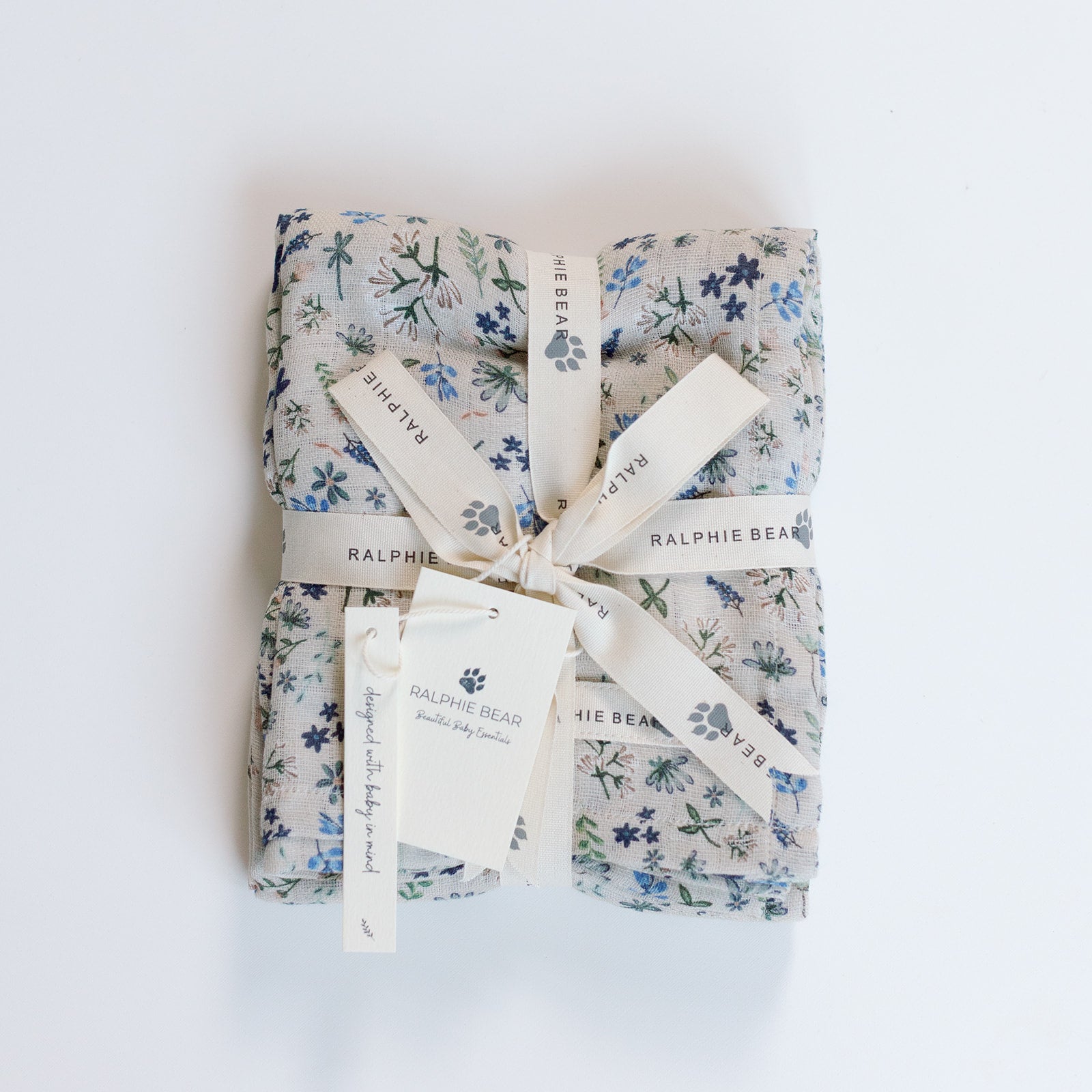 Gift wrapped in floral paper with a bow on a white background