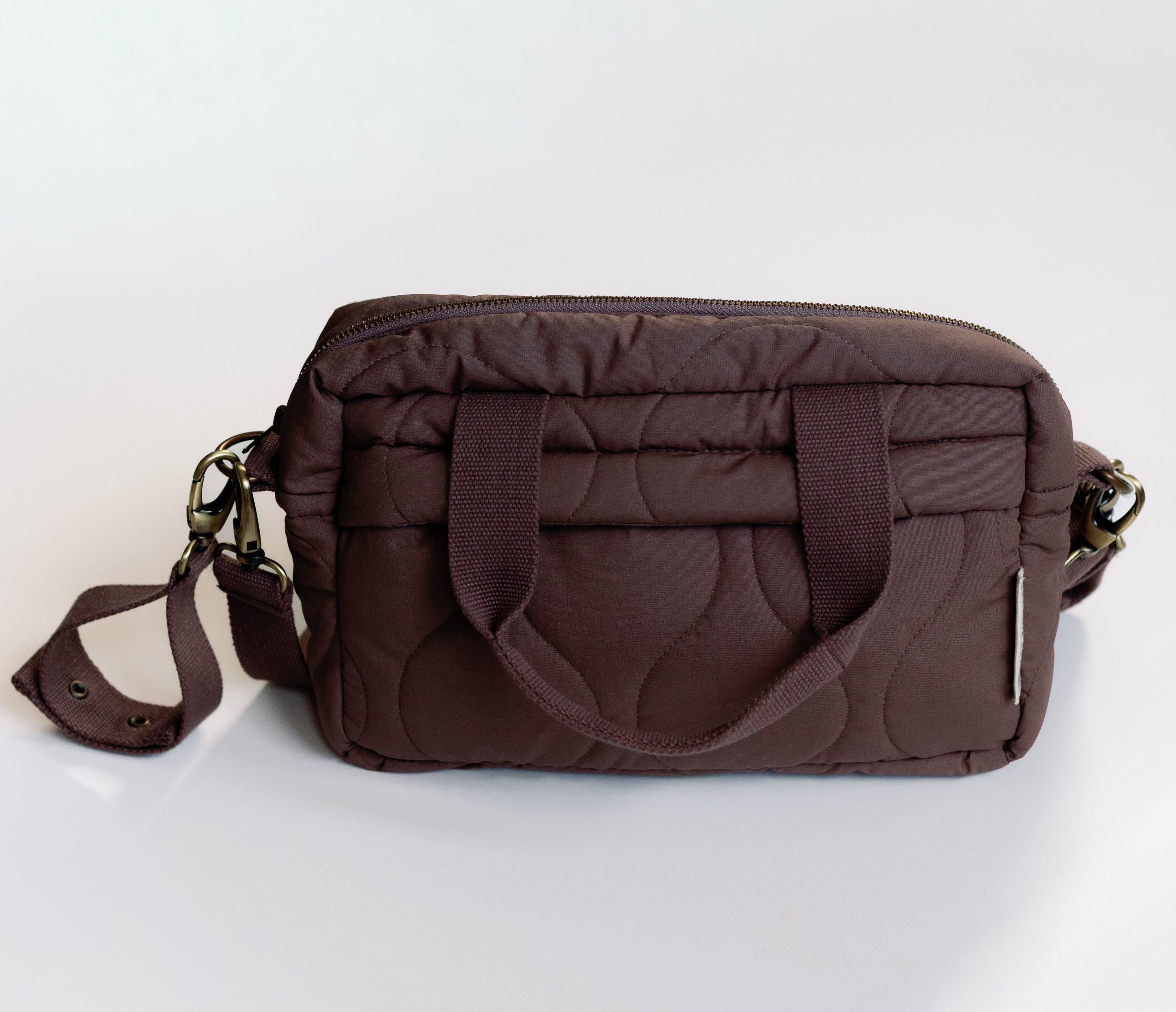 Brown quilted handbag on a white background