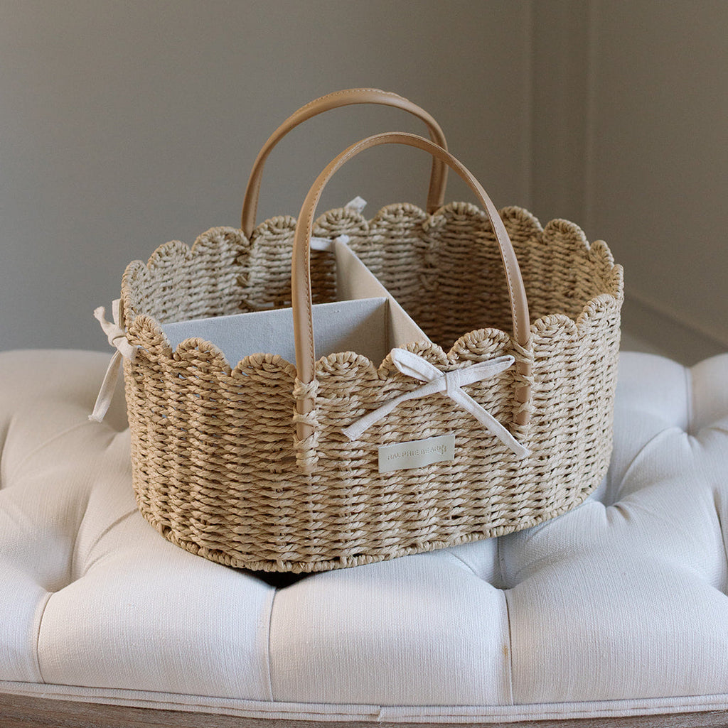 Woven basket with scalloped edges on a white cushioned surface