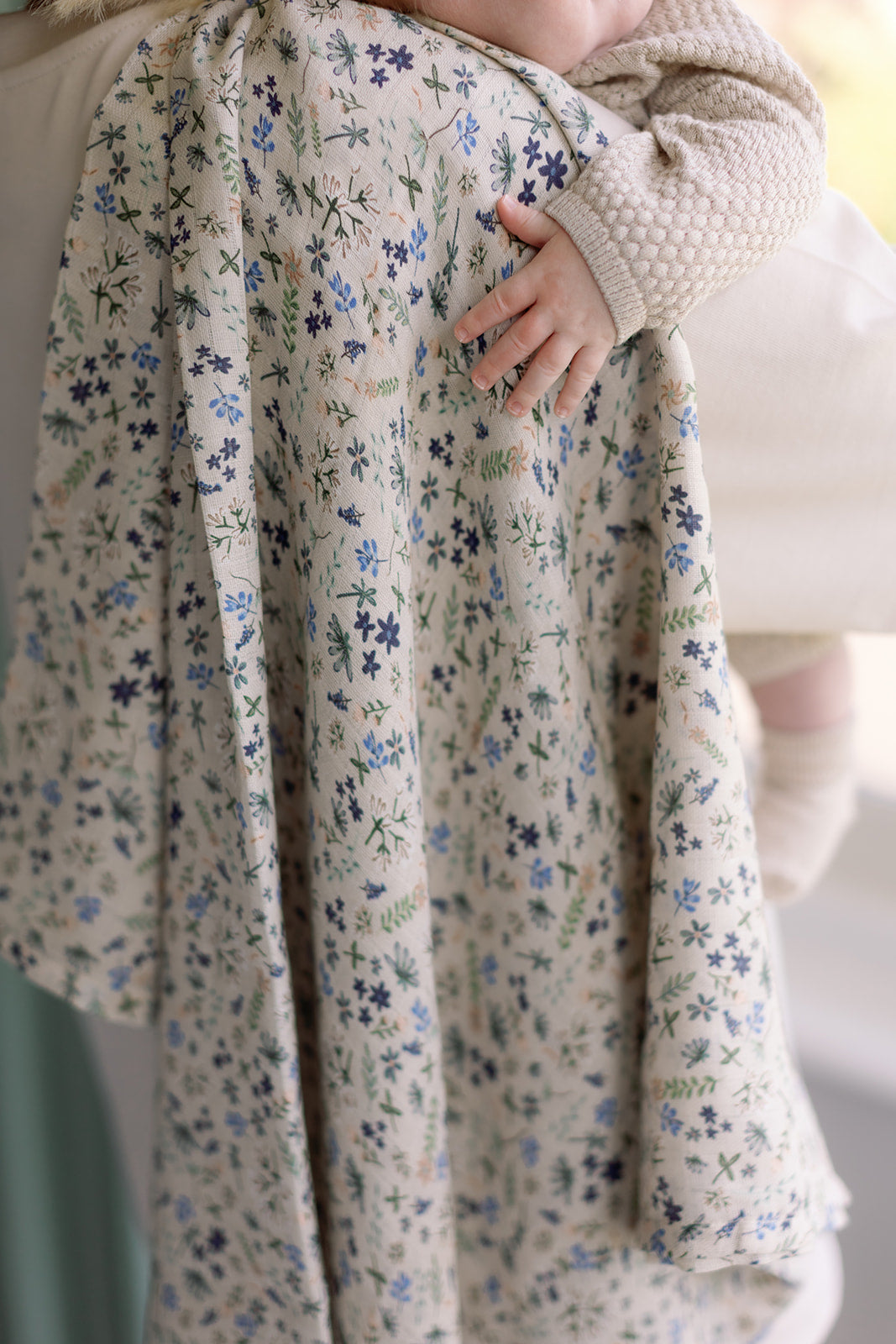 Floral-patterned fabric draped over a person with a blurred background