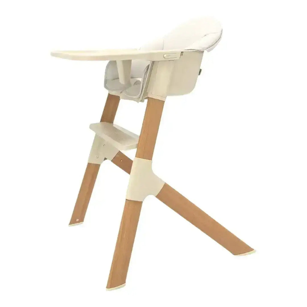 Wooden high chair with beige cushion on a white background