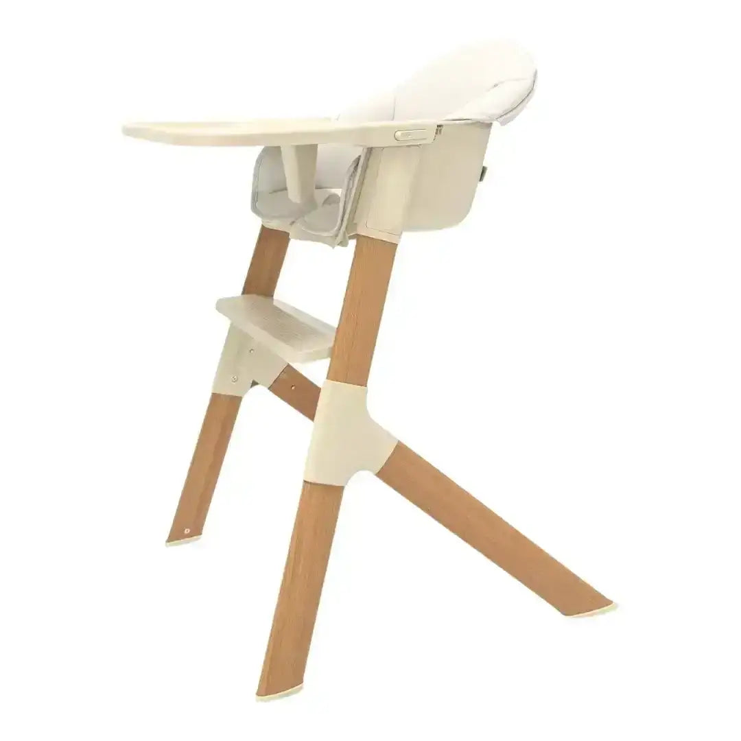 Wooden high chair with beige cushion on a white background