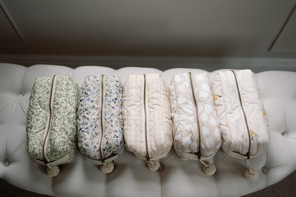 Five patterned bags on a white cushioned surface