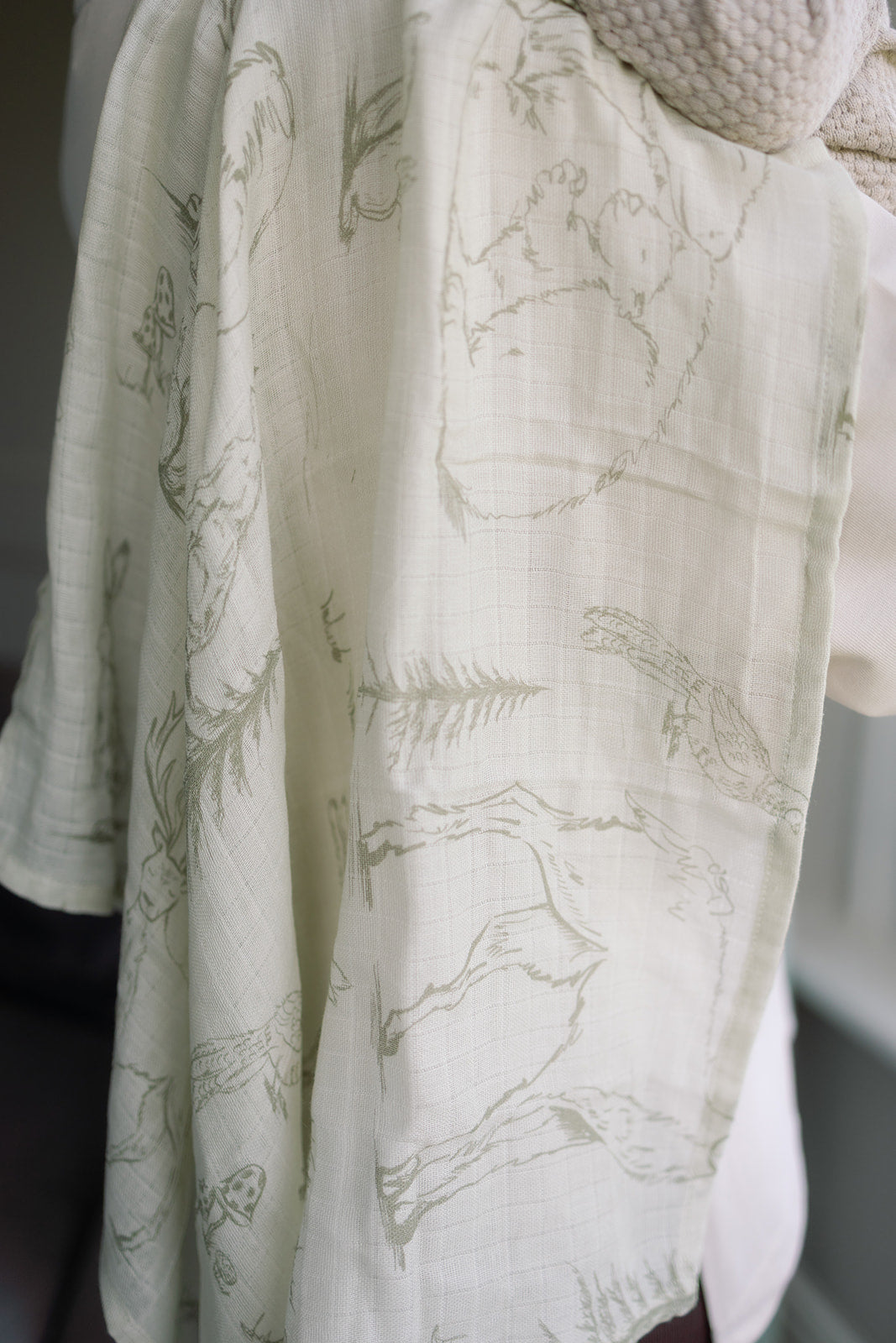 Close-up of a white garment with green leaf pattern