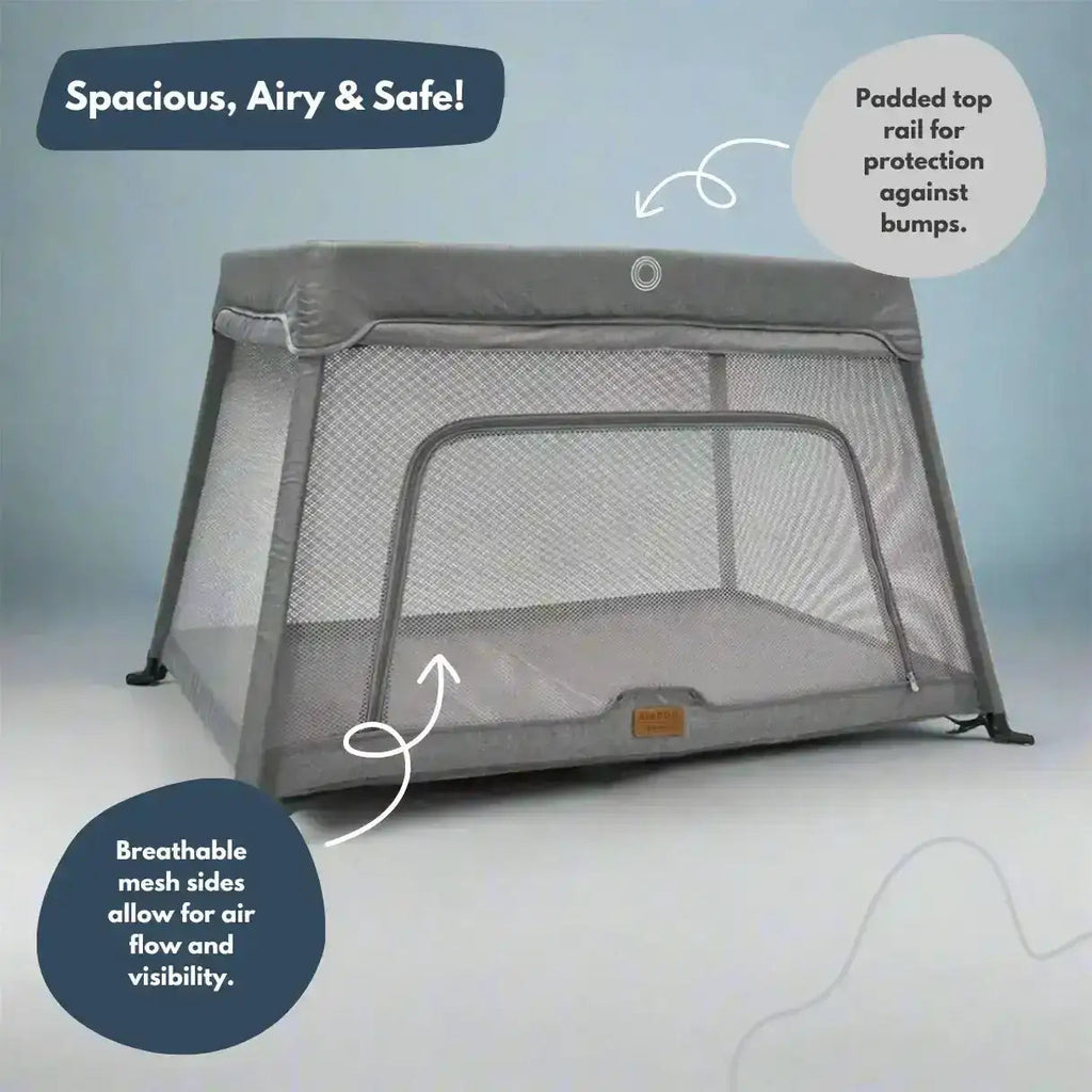 Portable crib with mesh sides and top rail on a light gray background