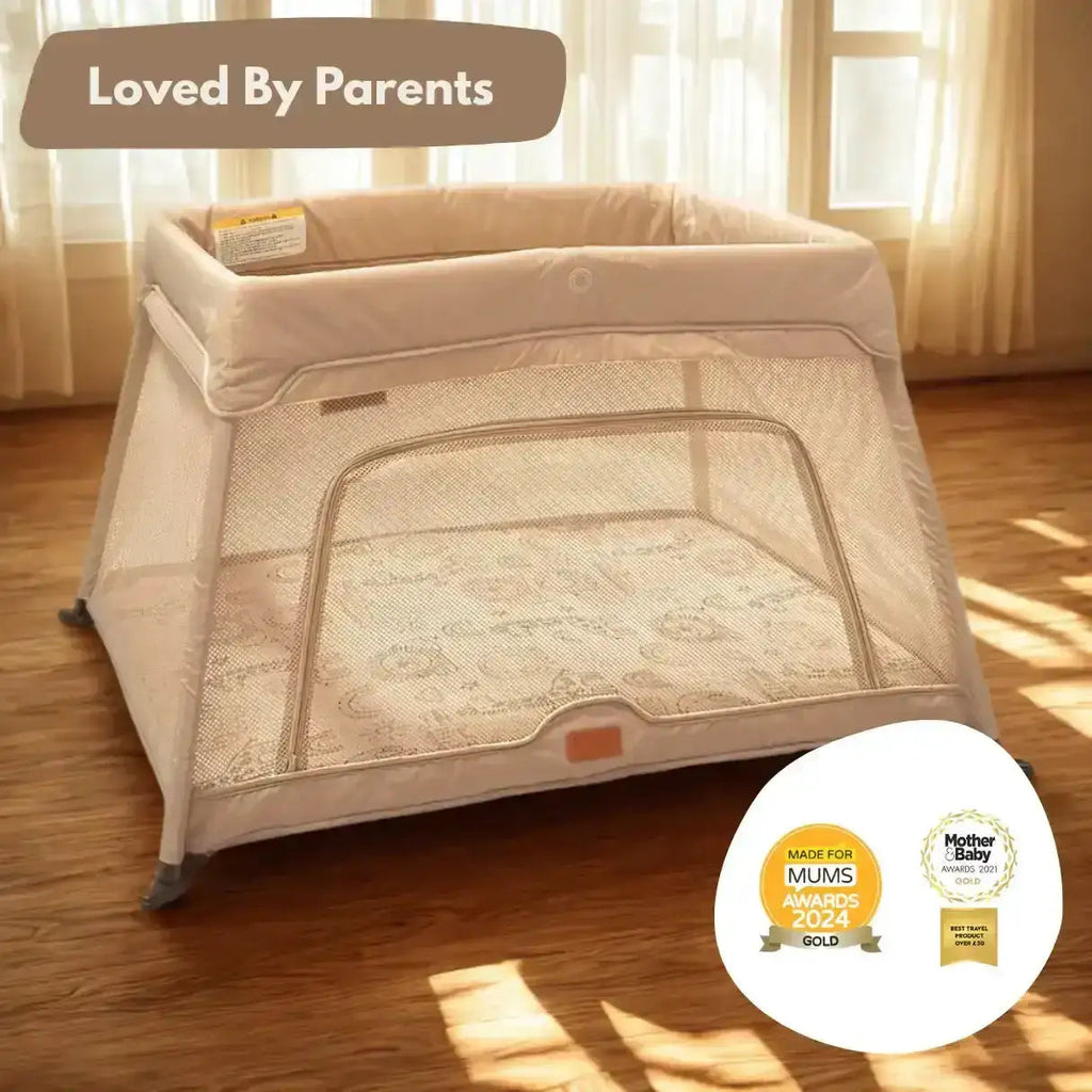 Beige baby playpen on a wooden floor with 'Loved By Parents' text and awards displayed.