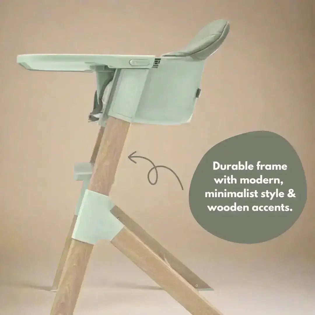 High chair with wooden legs and green seat and backrest on a beige background