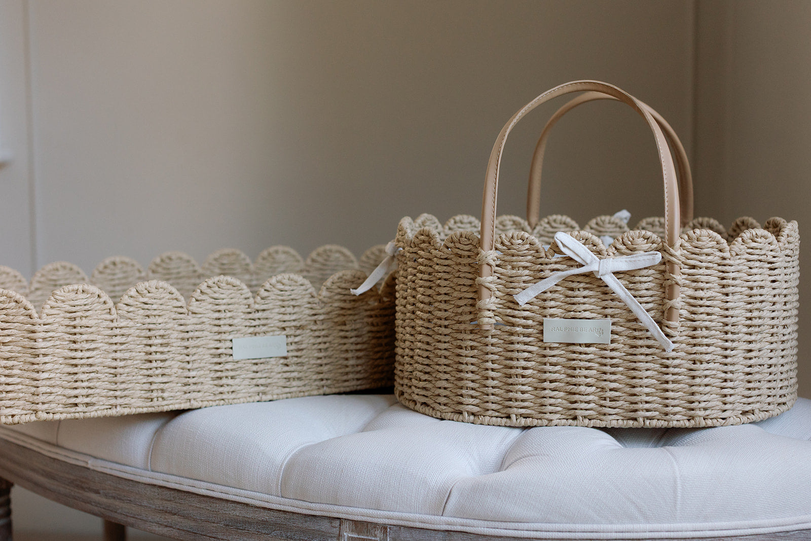 Woven baskets with decorative handles on a cushioned surface
