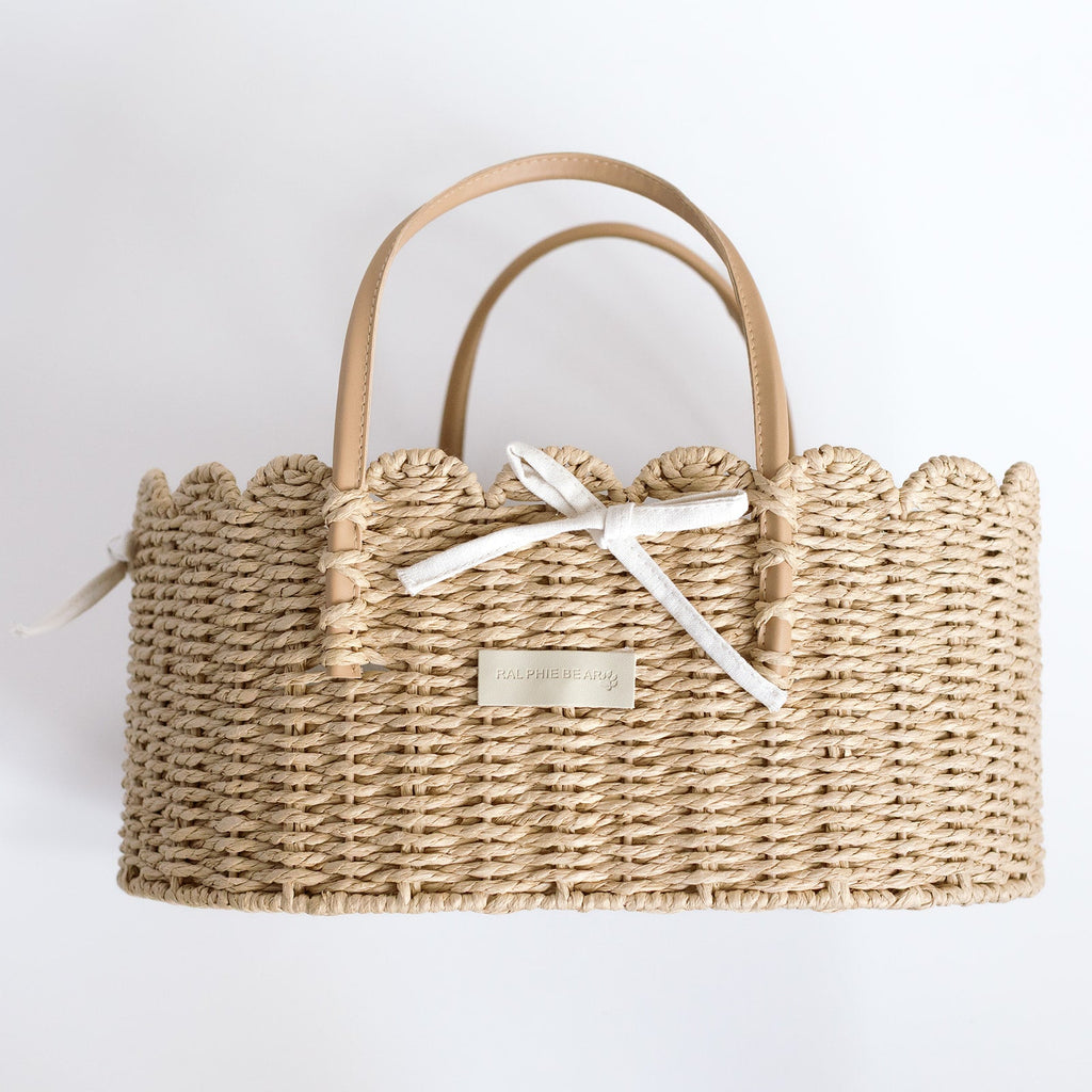 Woven handbag with a bow and visible brand name on a light background
