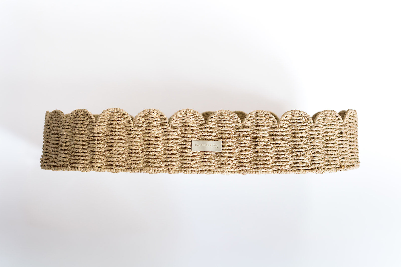 Woven basket with scalloped edge on a white background