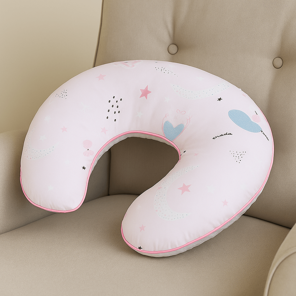 Pink neck pillow with star and balloon patterns on a beige couch