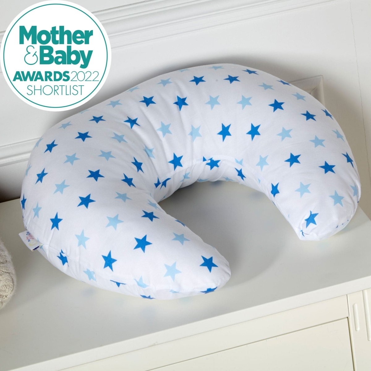 Breastfeeding pillow with blue star pattern on a white surface, featuring 'Mother & Baby Awards 2022 Shortlist' badge.