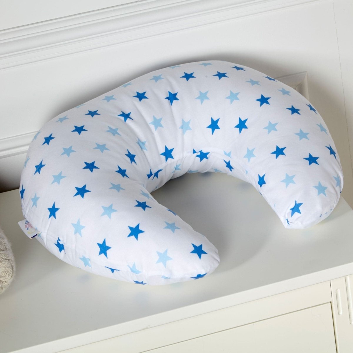 U-shaped pillow with blue star pattern on a white surface