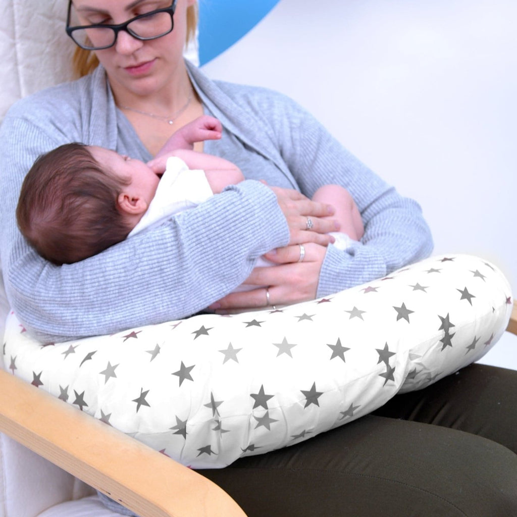 Woman holding a baby on a star-patterned cushion