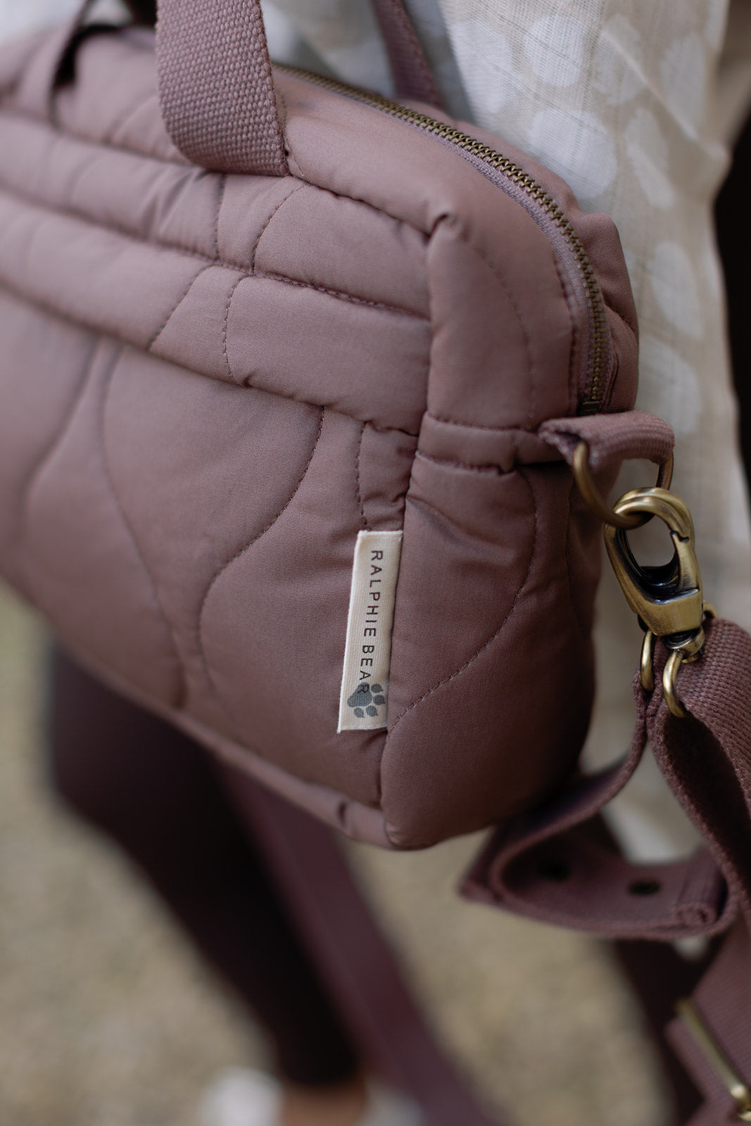 Close-up of a quilted handbag with a visible brand label on a blurred background
