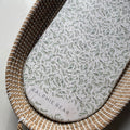 Wicker basket with a floral-patterned cushion labeled 'Ralphie Bear' on a light background