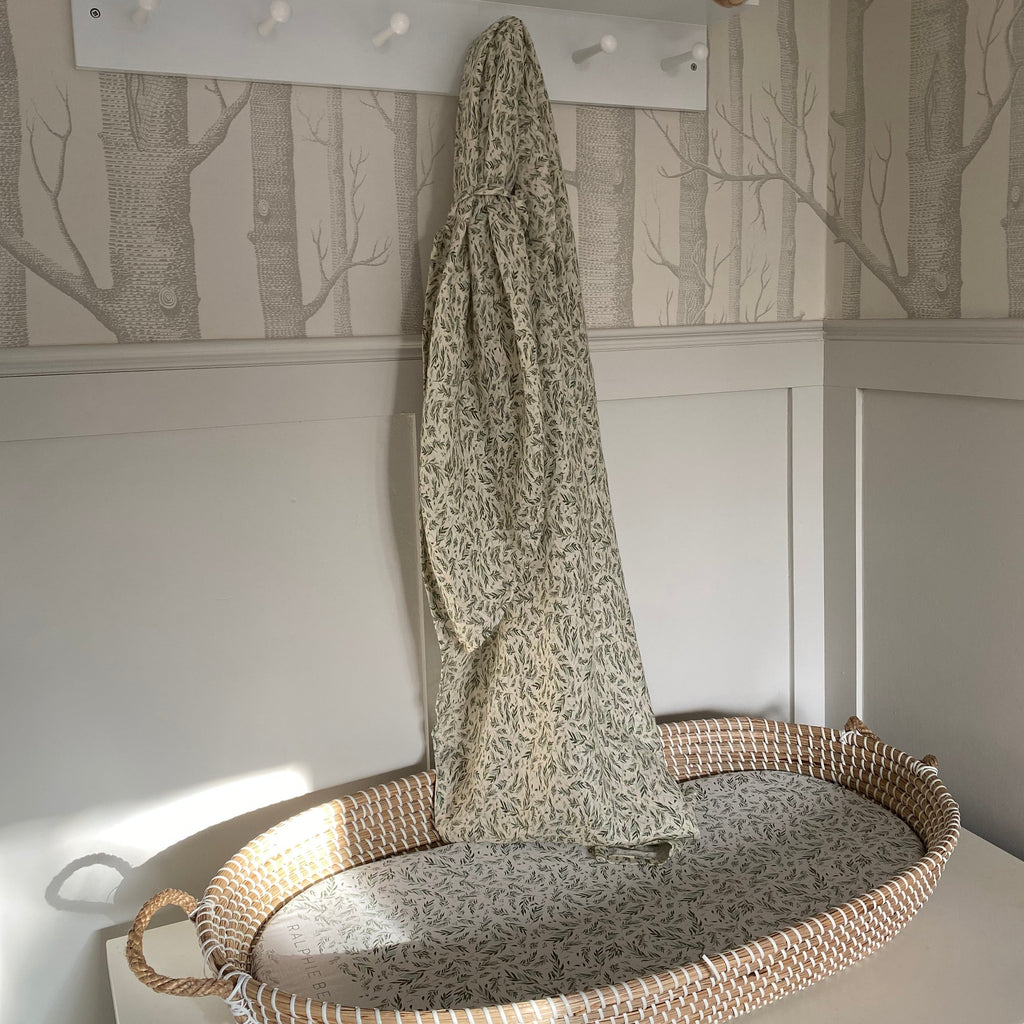 Nursery with a white shelf, woven basket, and patterned wall.