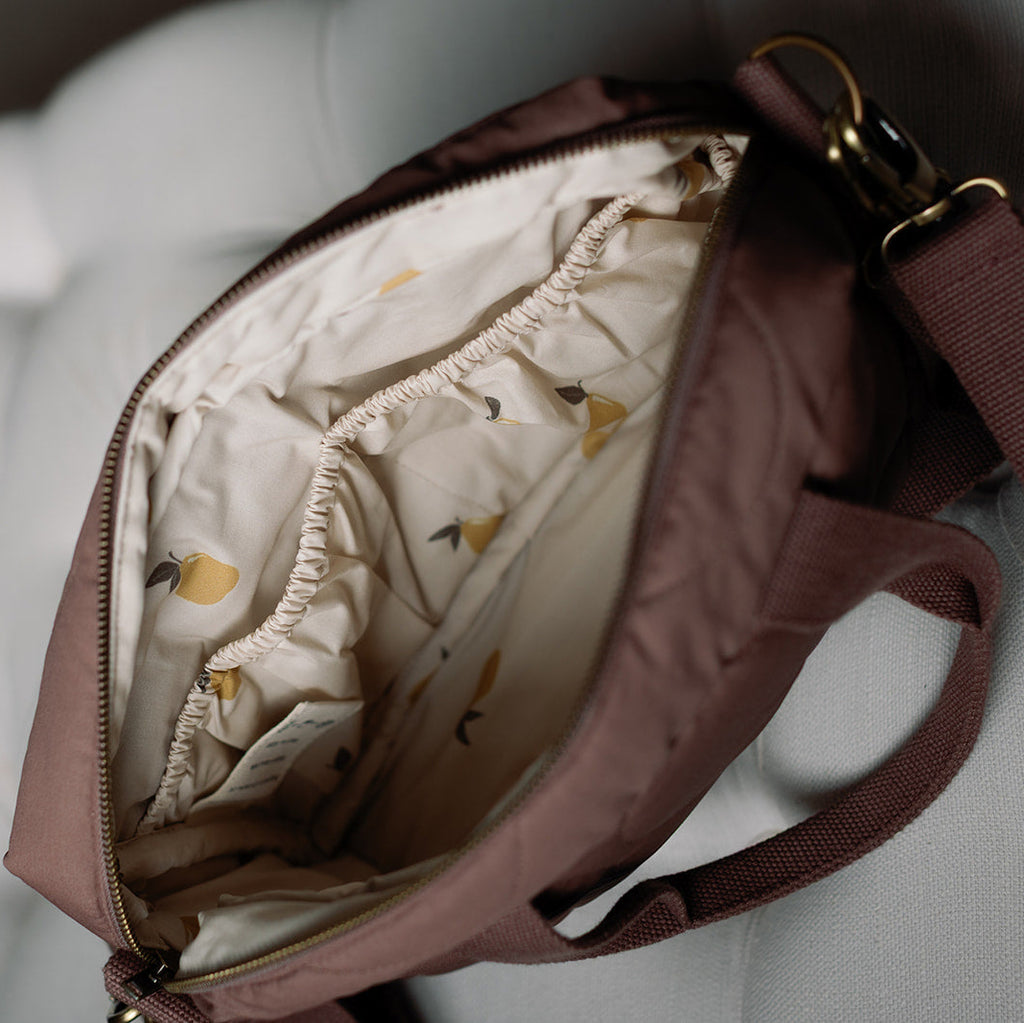 Open brown bag with a patterned interior on a light background