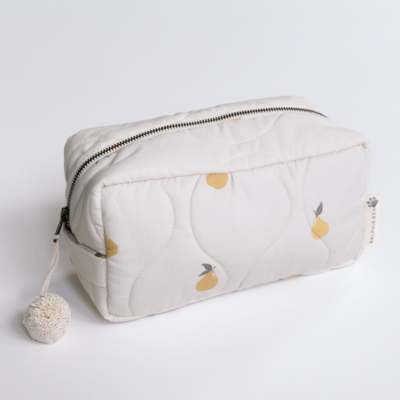 White pouch with pear pattern and pom-pom on a light gray background