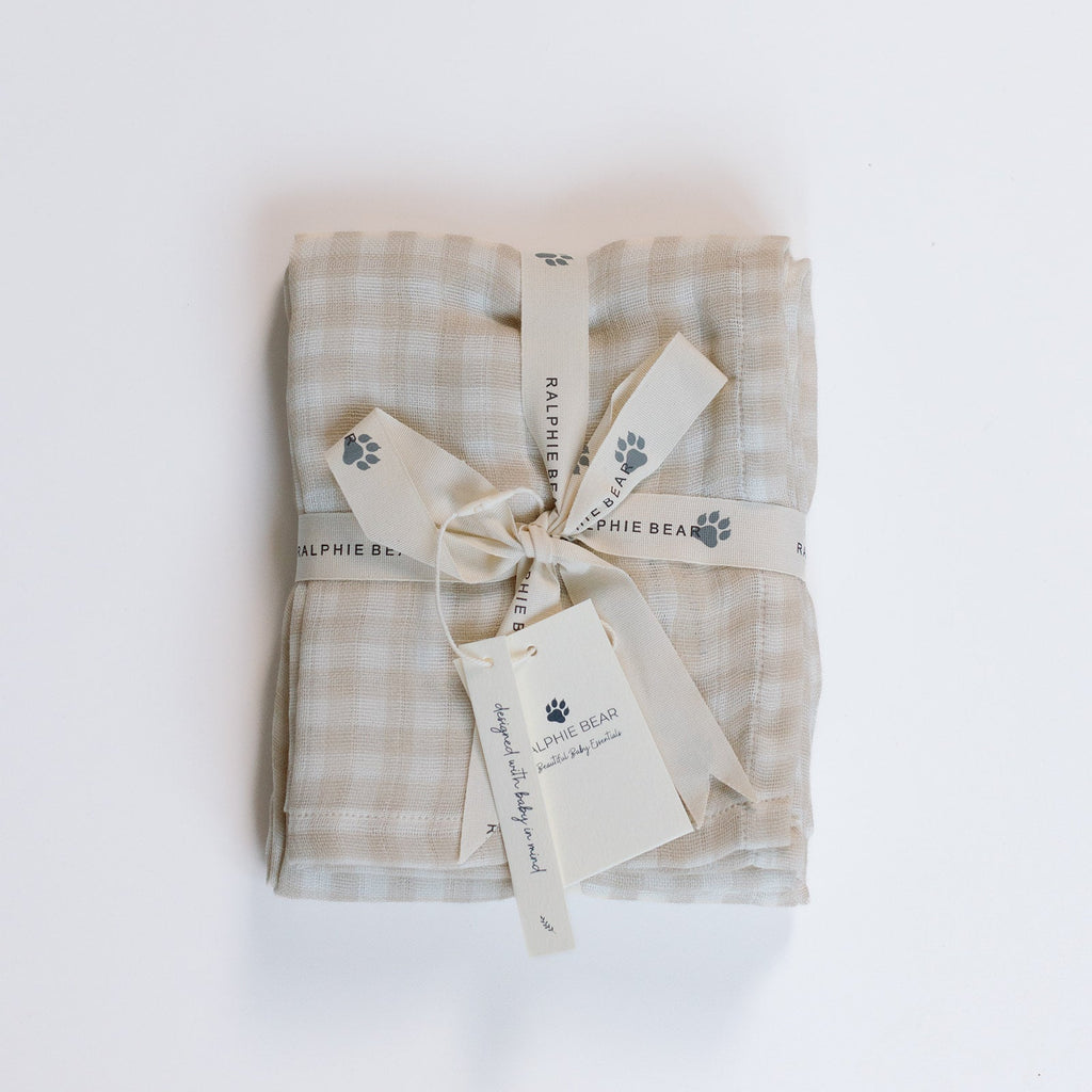 Folded checkered blanket with a bow and tags on a white background